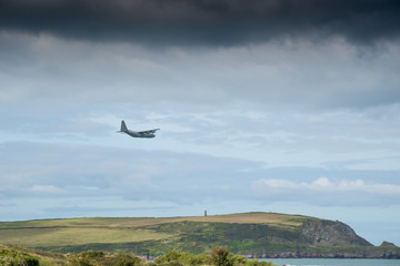 Camel estuary at Daymer Bay in Cornwall with a military transport plane in low-level flight.