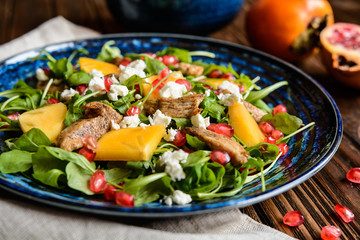 Arugula salad with pomegranate, chicken meat, persimmons and Feta cheese