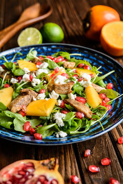 Arugula salad with pomegranate, chicken meat, persimmons and Feta cheese