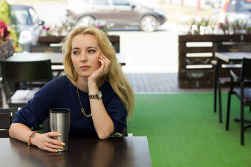 blonde woman is sitting in the cafe
