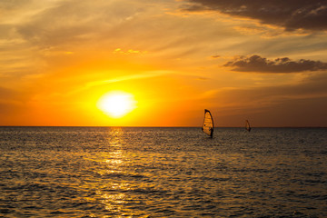 Silhouette of a wind-surfer on waves sunset
