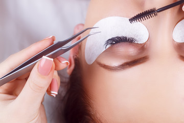 Eyelash Extension Procedure. Woman Eye with Long Eyelashes. Eyelashes with rhinestone. Lashes, close up, macro, selective focus.