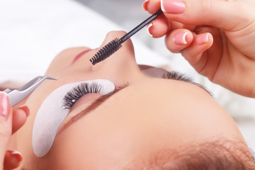 Eyelash Extension Procedure. Woman Eye with Long Eyelashes. Eyelashes with rhinestone. Lashes, close up, macro, selective focus.