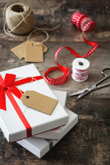 White gift with label with copy space boxes on wooden table

