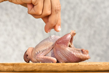 hand salting quail before cooking