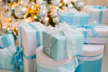 Christmas gift boxes with blue bow and bokeh lights on wooden surface