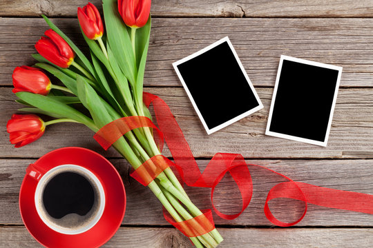 Red tulips, photo frames and coffee cup