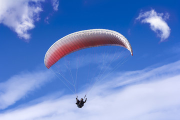 Paragliding on background of blue sky and white clouds