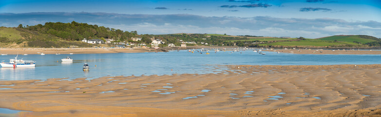 Fototapeta na wymiar Panorama of the Camel estuary at low tide with the touristic village Rock in Cornwall. View from Padstow on the opposite site of the estuary.