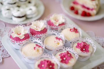 Close up, cupcakes on tray decorated with pink flowers