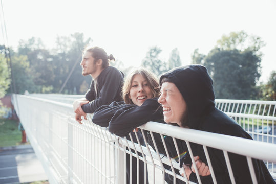 Three Young Beautiful Caucasian Man And Woman Friends Leaning On Handrail Having Fun - Friendship, Togetherness, Interaction Concept