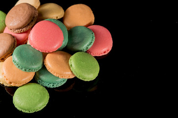 Sweet and colorful french macaroon or macaron on black background
