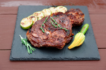 Rib eye steak with vegetables on slate plate