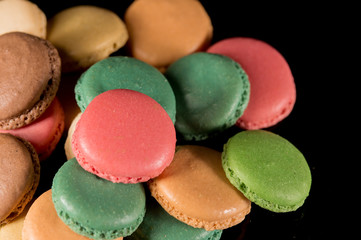 Sweet and colorful french macaroon or macaron on black background