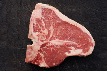T-bone steak on black cutting board