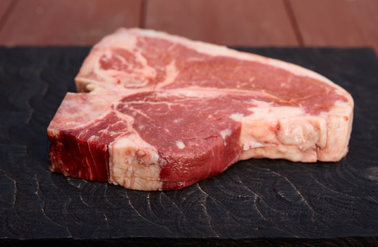 T-bone steak on black cutting board