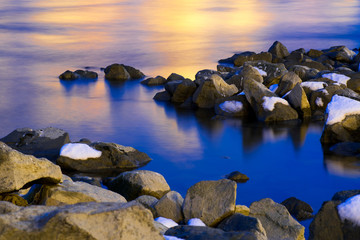Snow covered rocks by a river