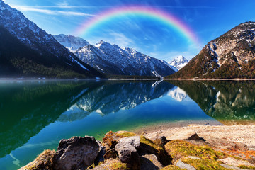Morning landscape with forest, mountains, lake and rainbow