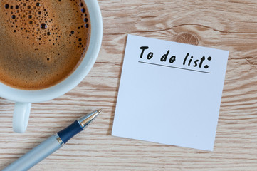 Coffee cup and notice with to do list on wooden rustic table from above, planning, design concept