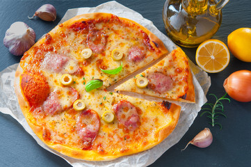 Delicious cheese pizza with salami next to ingredients