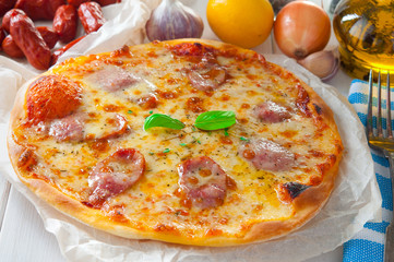 Delicious cheese pizza with salami next to ingredients