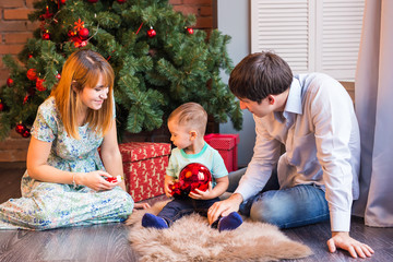 Christmas Family with child. Happy Smiling Parents and Children at Home Celebrating New Year. Christmas Tree.