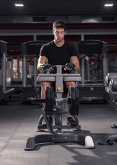man seated calf raise machine, gym.