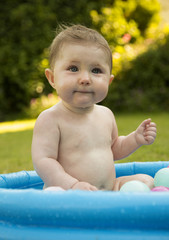 Fototapeta na wymiar baby girl in a paddling pool
