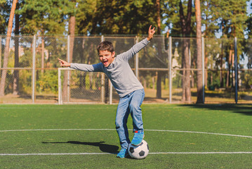 Joyful child celebrating success in football