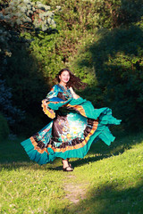 Beautiful gypsy girl in a traditional dance in the woods