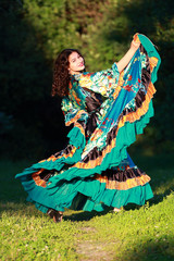Beautiful gypsy girl in a traditional dance in the woods