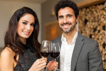 Young couple toasting wineglasses in a luxury restaurant