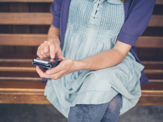 Woman using smartphone on bench