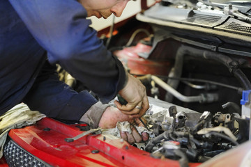 Worker repairs a car in a car repair center