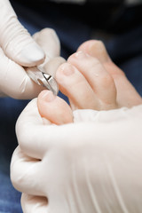 Manicurist uses professional tools for a pedicure