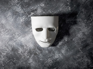 White mask on gray grunge background.