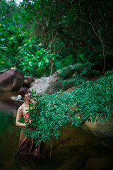 Beautiful girl with Thai dressing was playing water in the river.