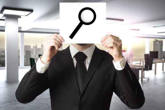 businessman hiding face behind sign loup magnifier