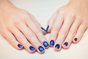 female hands with  blue nail Polish, close-up