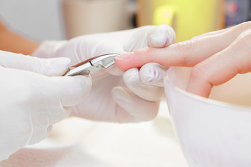 Manicurist uses  professional manicure tool.