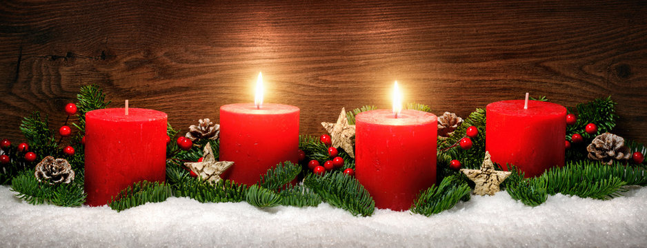 Advent Dekoration mit zwei Kerzenflammen, Schnee, Tannenzweigen und Holz Hintergrund