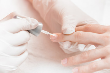 beautician applying Polish nails to women 