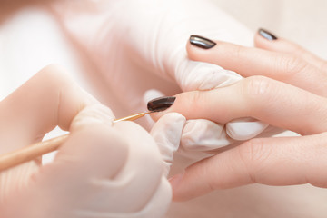 beautician applying Polish nails to women 