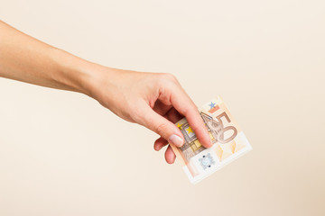 Woman's hand with money on a light background