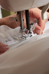 Young woman sewing fabric