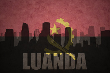 abstract silhouette of the city with text Luanda at the vintage angolan flag