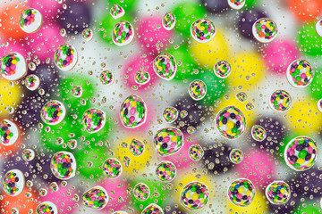 Colorful candies reflected in the water drops.