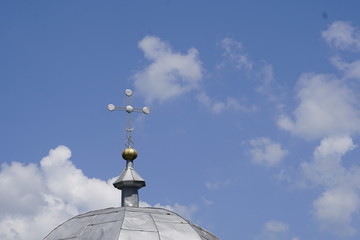 Fototapeta na wymiar cross on top of a church in front of bright blue sky