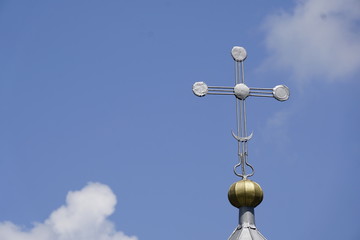 Fototapeta na wymiar cross on top of a church in front of bright blue sky