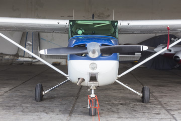 Single engine private lightweight aircraft in hangar.
